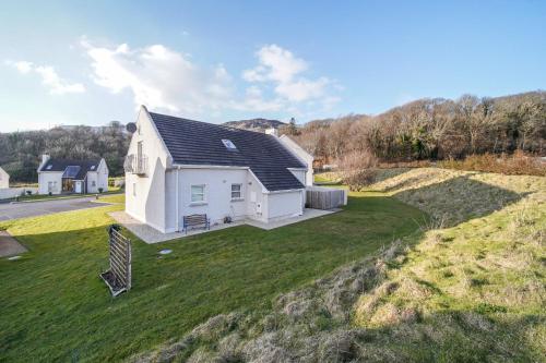 an aerial view of a white house on a lawn at 29 Fintra Bay with direct access to the beach in Saint Catherines