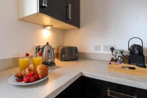 a plate of croissants and fruit on a kitchen counter at Walton by Holmesdale Homes in Milton Keynes