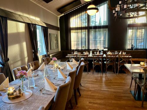 ein Esszimmer mit Tischen und Stühlen und Fenstern in der Unterkunft Big River Camp Hotel & Spa in Föllinge