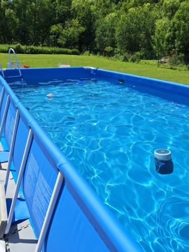 a blue swimming pool with a bucket in the water at Vila Pohoda Javorníky s rozľahlým pozemkom in Makov