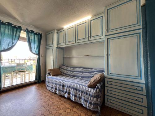 - une chambre avec un lit avec des placards et une fenêtre dans l'établissement Appartement Studio Cabine - Gruissan GN020-211, à Gruissan