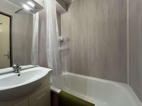 La salle de bains est pourvue d'un lavabo, d'une baignoire et d'une baignoire blanche. dans l'établissement Appartement Studio Cabine - Gruissan GN020-211, à Gruissan