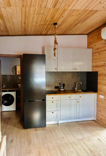 a kitchen with a stainless steel refrigerator and white cabinets at Žvejo Namelis prie Jūros in Melnragė