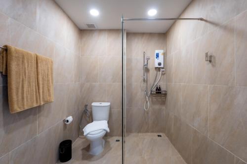 a bathroom with a toilet and a glass shower at Seaside Naithon Phuket - Newly Opened in Nai Thon Beach