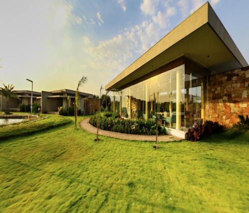 a building with a lawn in front of it at Araiya Gir,A Mavintara Resort in Chitrāwal