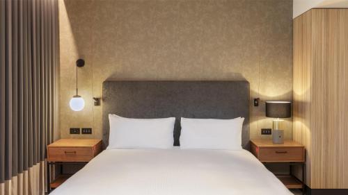a bedroom with a large bed with white pillows at Hilton Woking in Woking