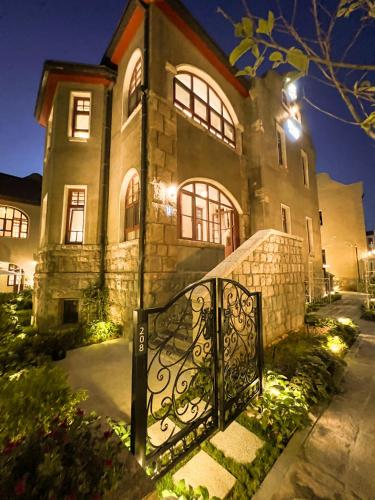 a large stone house with a gate in front of it at TUIWA Garden Holiday Villa in Qingdao