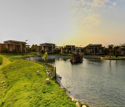a boat in a river in front of some houses at Araiya Gir,A Mavintara Resort in Chitrāwal