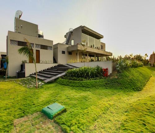 a house with a lawn in front of it at Araiya Gir,A Mavintara Resort in Chitrāwal