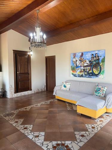 a living room with a couch and a painting on the wall at Ai confini dell Etna 1 in Nunziata