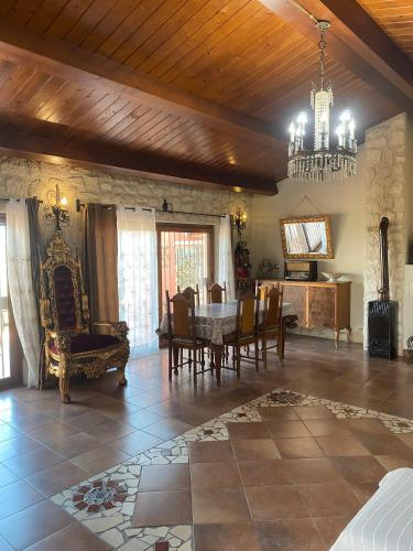 a living room with a table and chairs and a chandelier at Ai confini dell Etna 1 in Nunziata