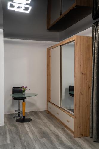 a room with a table and a glass cabinet at Bogdan Premium Suites - Targu Jiu in Târgu Jiu