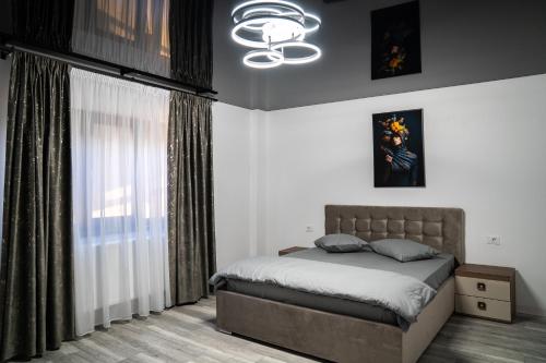 a bedroom with a bed and a chandelier at Bogdan Premium Suites - Targu Jiu in Târgu Jiu