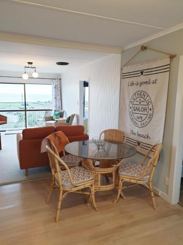 a living room with a table and chairs and a couch at Pura Vida by the Sea in Riverton
