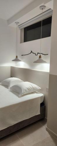 - une chambre avec un lit et deux lampes suspendues dans l'établissement L'Oustaou Paradis, à Marseille