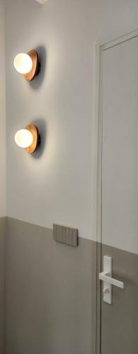 une salle de bain avec deux lumières sur le mur à côté d'une douche dans l'établissement L'Oustaou Paradis, à Marseille