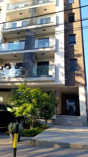 Un edificio con un estacionamiento enfrente. en Apartman 25, en Belgrado