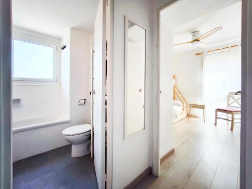 ein weißes Bad mit einem WC und einem Fenster in der Unterkunft Refugio Costero en S'Agaró cerca de Playas Top in S'Agaró