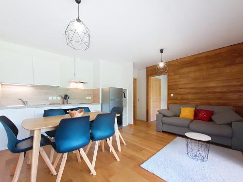 Il dispose d'une cuisine et d'un salon avec une table et des chaises bleues. dans l'établissement Loges de Celestin LTB103 NATURE & MOUNTAIN 4 Pers, à Châtel