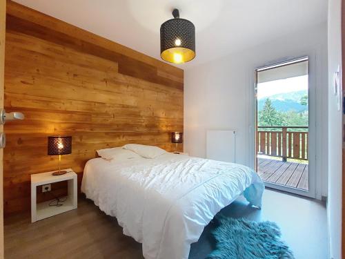 une chambre avec un lit et un mur en bois dans l'établissement Loges de Celestin LTB103 NATURE & MOUNTAIN 4 Pers, à Châtel