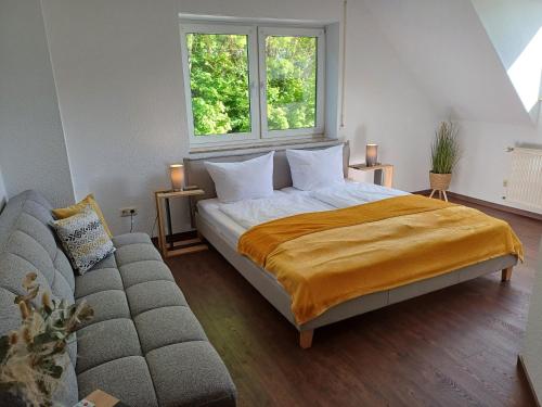 una camera da letto con un letto e un divano di Gästehaus am Radweg a Herbstein