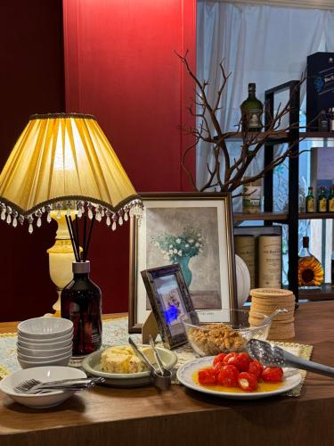 a table topped with plates of food and a lamp at Sangju Hotel Seoul in Seoul