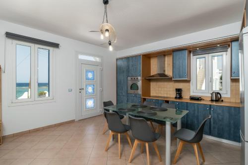 a kitchen and dining room with a table and chairs at Villa Azzure Horizon Pollonia in Pollonia