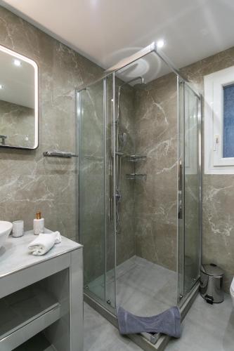 a glass shower in a bathroom with a sink at Villa Azzure Horizon Pollonia in Pollonia