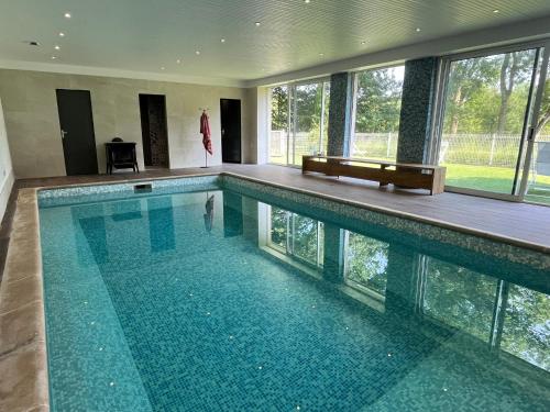 a swimming pool in a house with a large window at Manoir du Val Fouzon - Beauval in La Vernelle