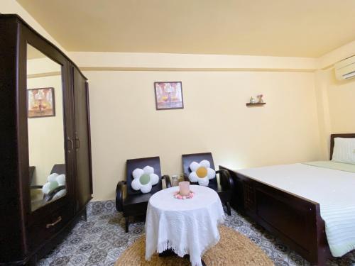 a bedroom with a bed and a table and chairs at Daisy Homestay Hoian in Hoi An