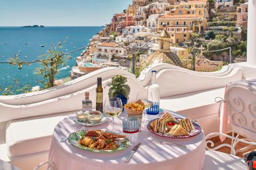 a table with two plates of food and a view of the city at Le Sirenuse in Positano