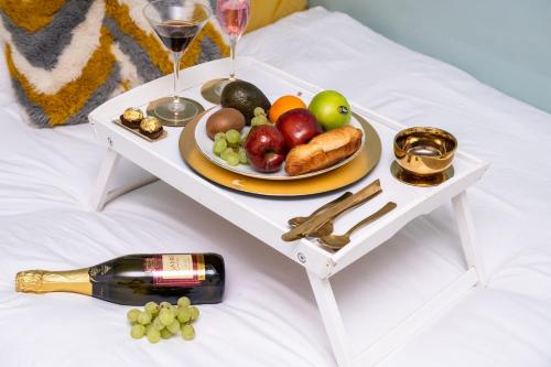 a tray with a plate of fruit and a bottle of wine at The Private Villa, Northampton Centre, 4 bedrooms, Sleeps 9 in Northampton