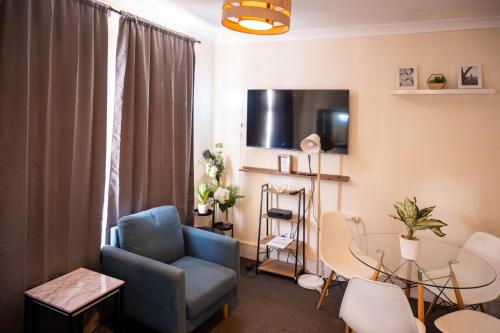 a living room with a chair and a table at The Private Villa, Northampton Centre, 4 bedrooms, Sleeps 9 in Northampton