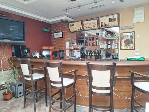 a bar with five chairs in a restaurant at Hotel Elica in Varna City