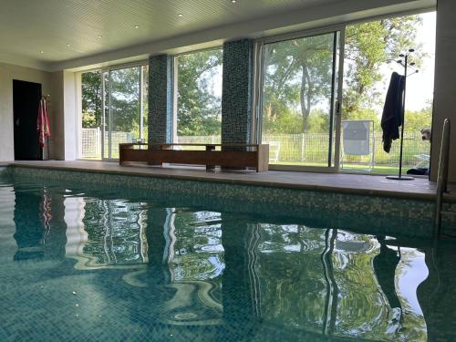 a swimming pool in a house with a reflection in the water at Manoir du Val Fouzon - Beauval in La Vernelle