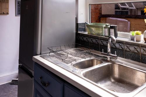 a kitchen with a sink and a refrigerator at The Private Villa, Northampton Centre, 4 bedrooms, Sleeps 9 in Northampton