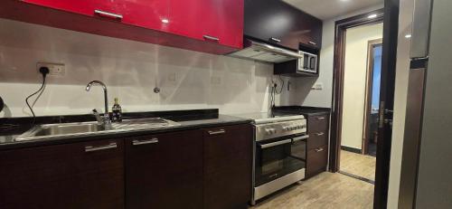a kitchen with a sink and a stove at Nasma Homes in Abu Dhabi
