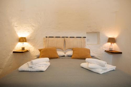 a room with two white pillows and two lamps at Trullo Elce 11 in Putignano