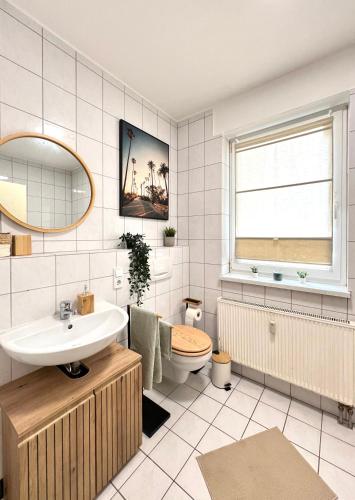 a bathroom with a sink and a toilet and a window at Ferienwohnung Burgstraße in Manderscheid