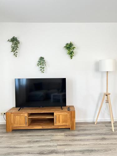 a living room with a flat screen tv on a wooden entertainment center at Ferienwohnung Burgstraße in Manderscheid