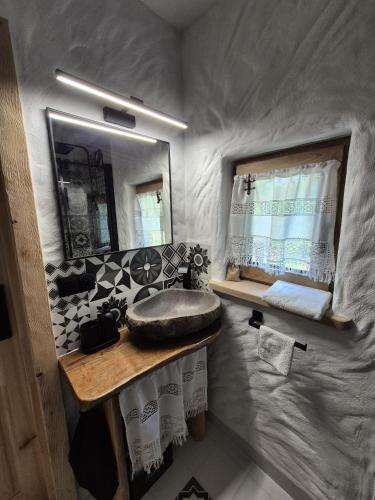 a small bathroom with a sink and a mirror at Woodland House 1 in Berezka