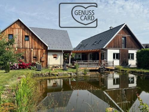 two barns with a pond in front of a house at AMD Chalet in Stang bei Hatzendorf