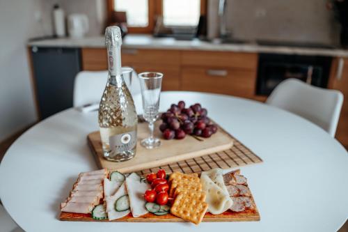 a white table with a tray of cheese and fruit at Gorczańska Sapałówka in Maniowy