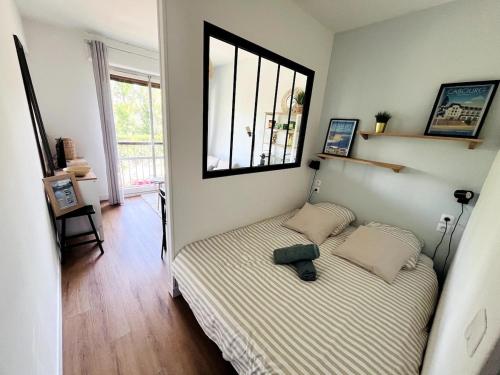 une petite chambre avec un lit et une fenêtre dans l'établissement Studio cosy 80 m de la plage, à Cabourg
