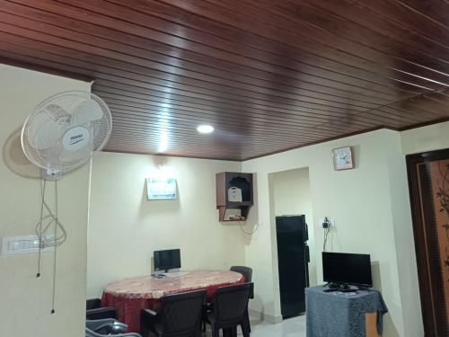 ein Raum mit einem Tisch mit Stühlen und einem Ventilator in der Unterkunft Holiday cottage in Madikeri