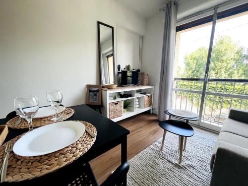 - un salon avec une table et des verres à vin dans l'établissement Studio cosy 80 m de la plage, à Cabourg
