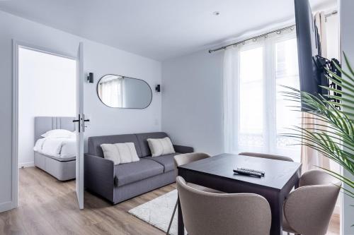 un salon avec un canapé et une table dans l'établissement Chic 4-Star Studio Only 10 Minutes from Le Marais, à Paris