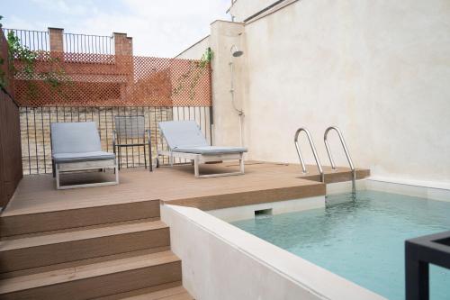 a patio with two chairs and a swimming pool at Arena Centro Rooms&Suites, by Homing U in Seville