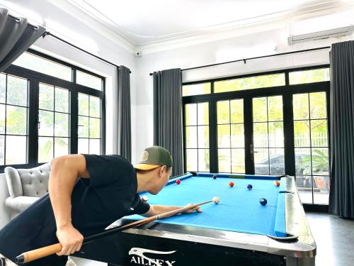 a man playing pool in a living room at Tony Villa Homestay Ba Vì in Ba Vì