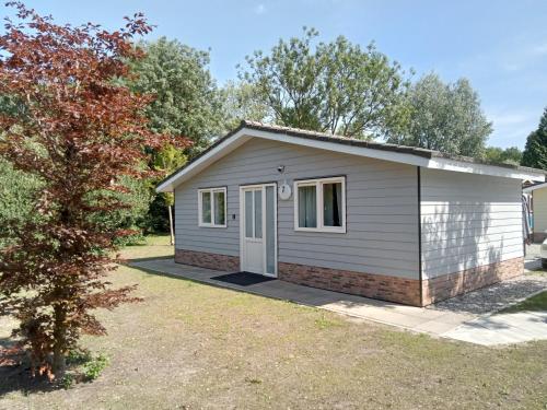 a small shed with a white door in a yard at Domstad Resort Utrecht Vakantiewoningen in Utrecht